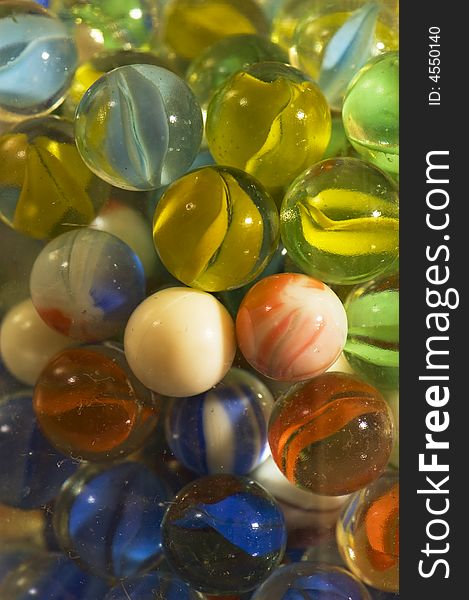 Close up of colourful marbles. Many colors. scratches on marbles and bottle visible. Close up of colourful marbles. Many colors. scratches on marbles and bottle visible.