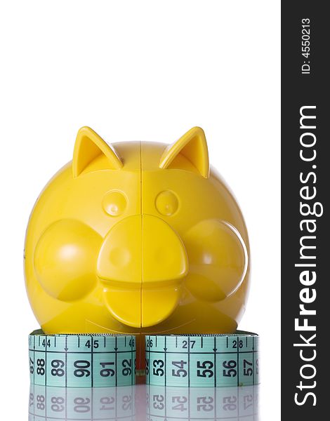 Yellow piggy bank and measuring tape, on white background