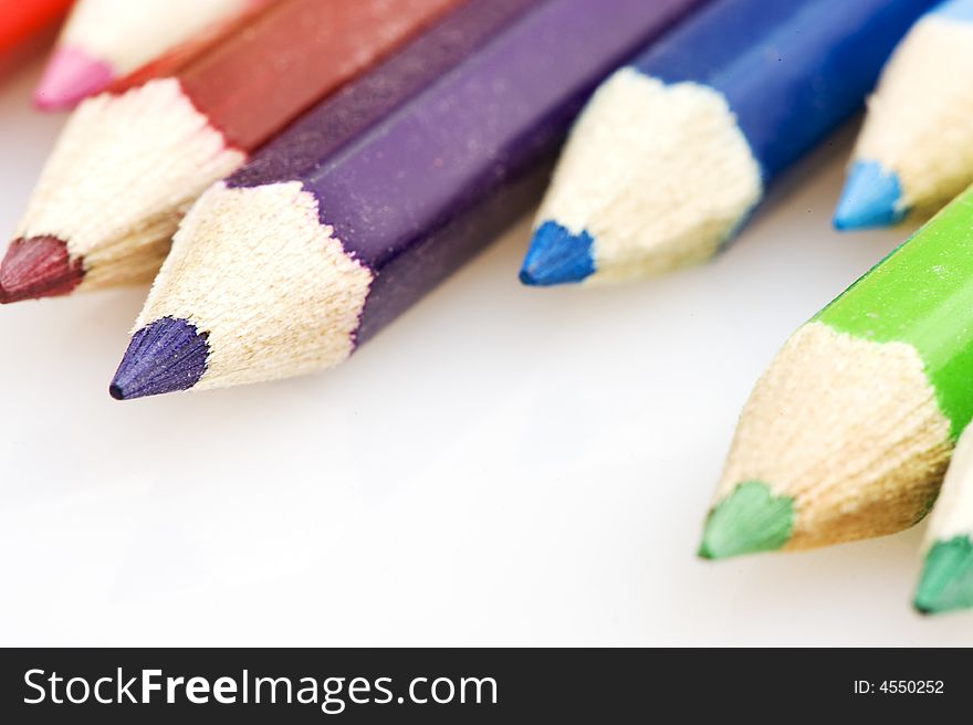 Pencils in different colors. Pencils placed uneven. focus on purple pencil. Pencils in different colors. Pencils placed uneven. focus on purple pencil.