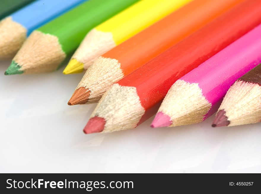 Pencils in different colors. Pencils placed uneven. focus on orange pencil. Pencils in different colors. Pencils placed uneven. focus on orange pencil.