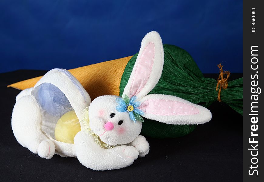 Rabbit with easter eggs in front of a big carrot. Rabbit with easter eggs in front of a big carrot