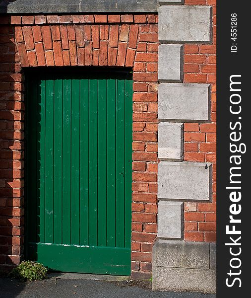 A green door in an old red brick wall