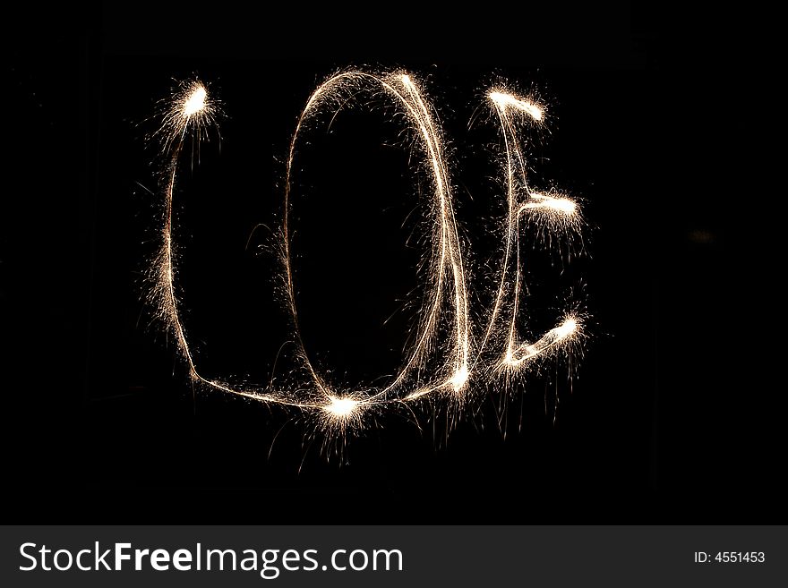 Word love written with sparkling fire on black background. Word love written with sparkling fire on black background