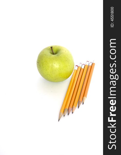 Colorful pencils and apple on white