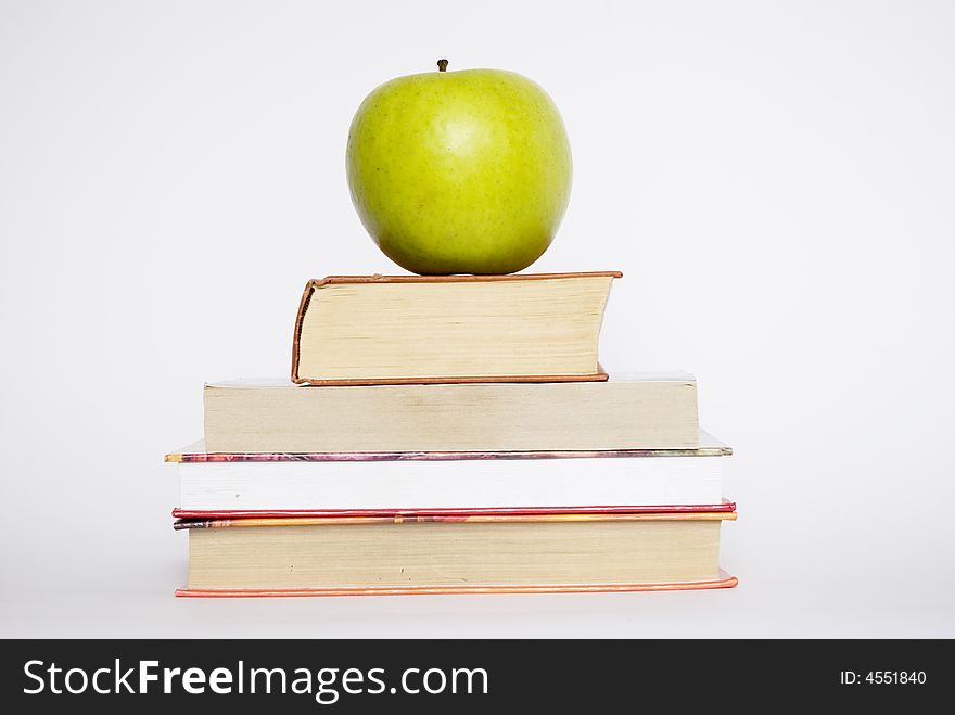 Green apple and stack of books