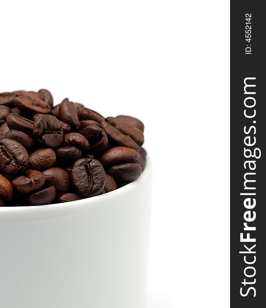 Close up of a cup of coffee beans over white