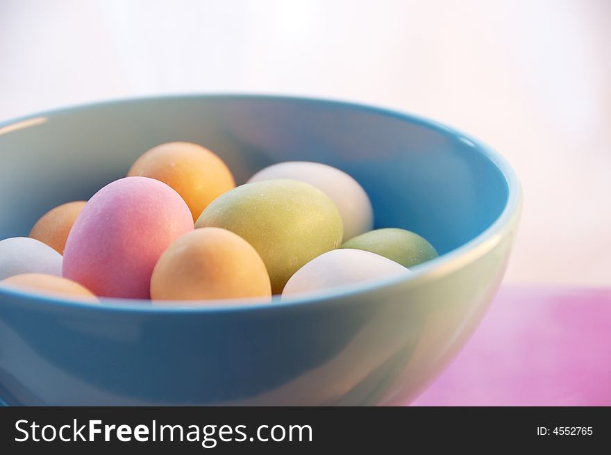 Multi colored easter eggs in a blue bowl. Multi colored easter eggs in a blue bowl.