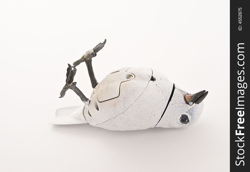 Mechanical bird painted white in a dead like position.  The camera angle is from above looking down. Mechanical bird painted white in a dead like position.  The camera angle is from above looking down.