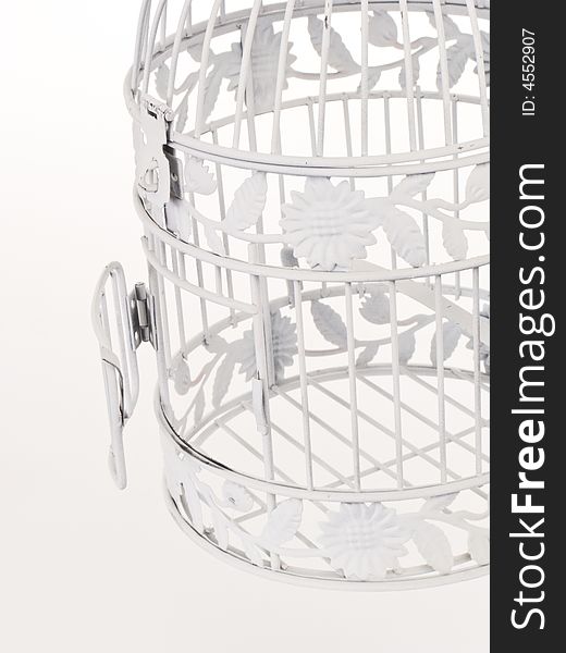 White bird cage against a white background with a cage door slightly ajar. White bird cage against a white background with a cage door slightly ajar.