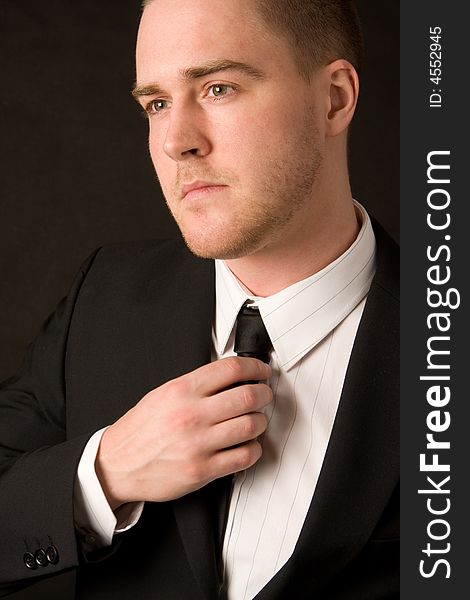 Portrait of a young businessman on black background