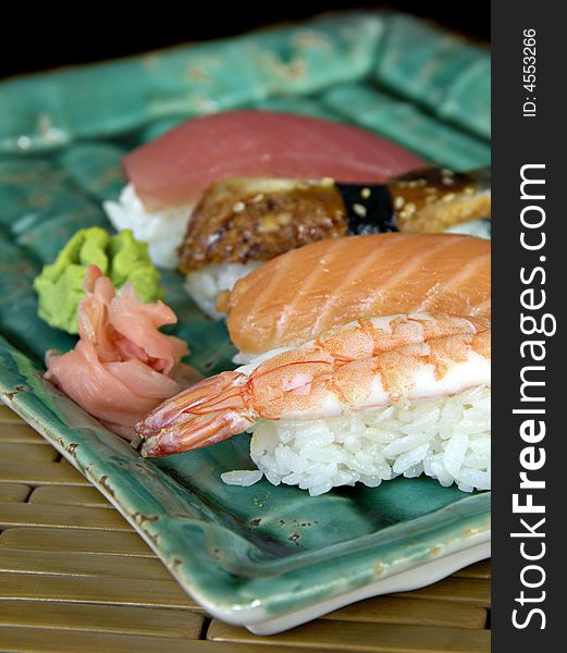 Different types of sushi lined up on a plate. Different types of sushi lined up on a plate.