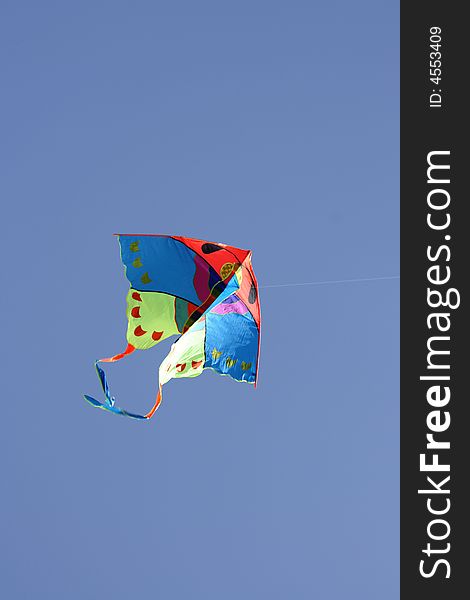 Colorful kite flying in the air on a clear sky background