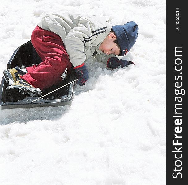 Boy in winter rides on sled with mountains. Boy in winter rides on sled with mountains