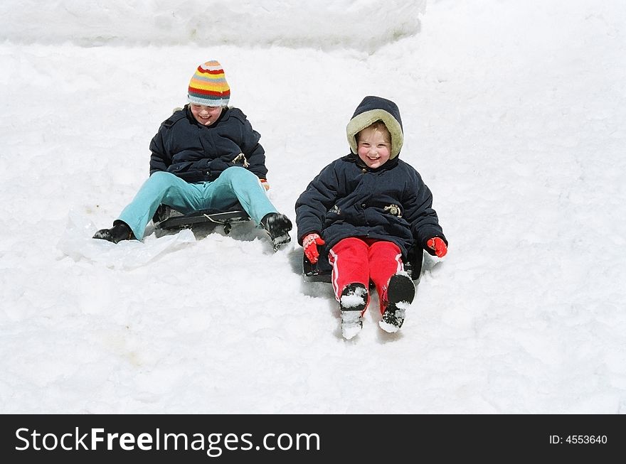 Children  in winter rides on sled with mountains. Children  in winter rides on sled with mountains