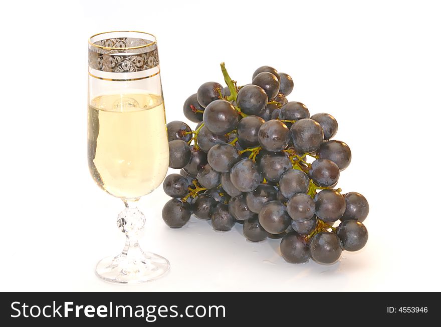 Glass of white wine and bunch of the black grapes, isolated on a white background. Glass of white wine and bunch of the black grapes, isolated on a white background