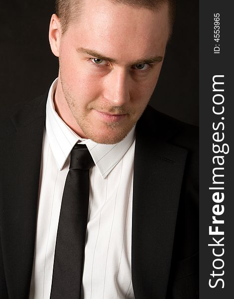 Portrait of a young businessman on black background
