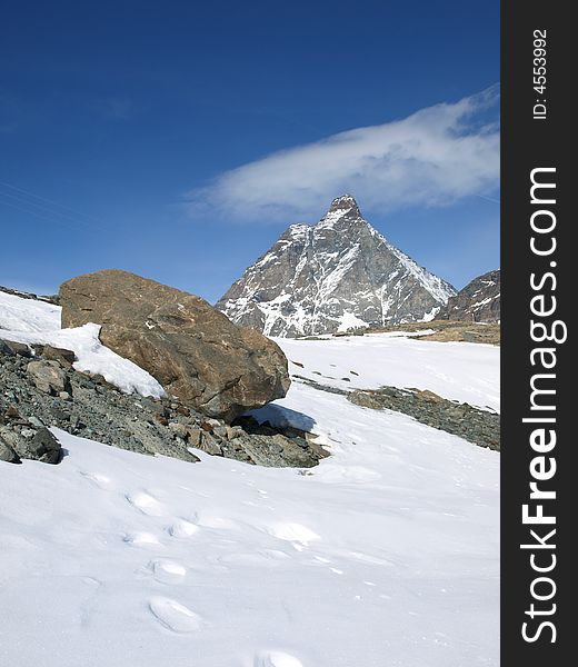The big warm stone in a snow, on a background of Matterhorn