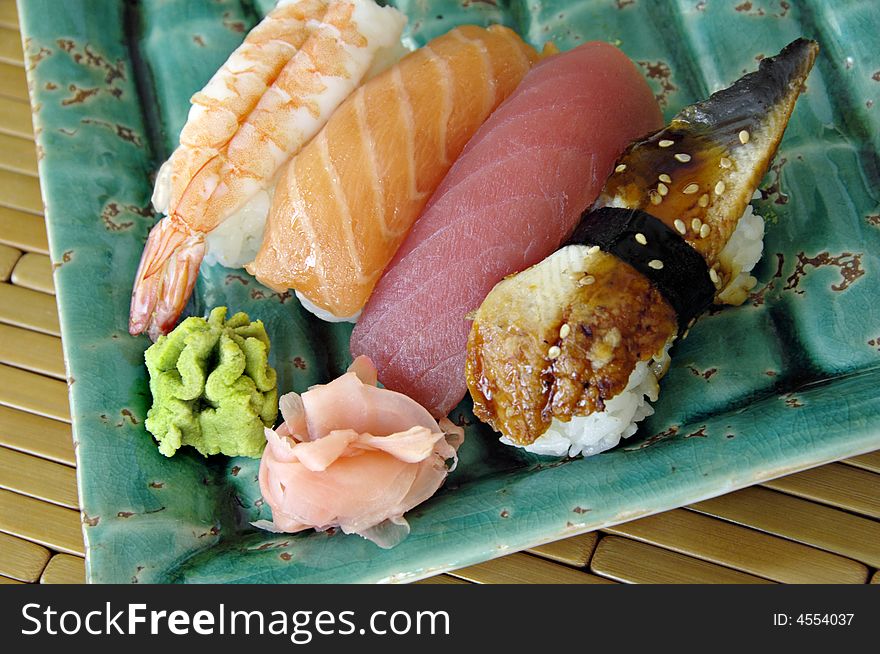 Different types of sushi lined up on a plate. Different types of sushi lined up on a plate.