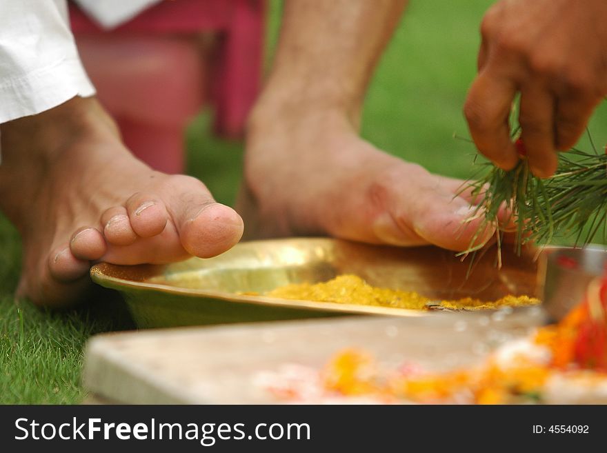 Hindu marriage ceremony. Cleansing of a groom's feet with turmeric. Hindu marriage ceremony. Cleansing of a groom's feet with turmeric.