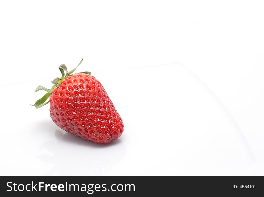 Ripe strawberry with reflection on a plate