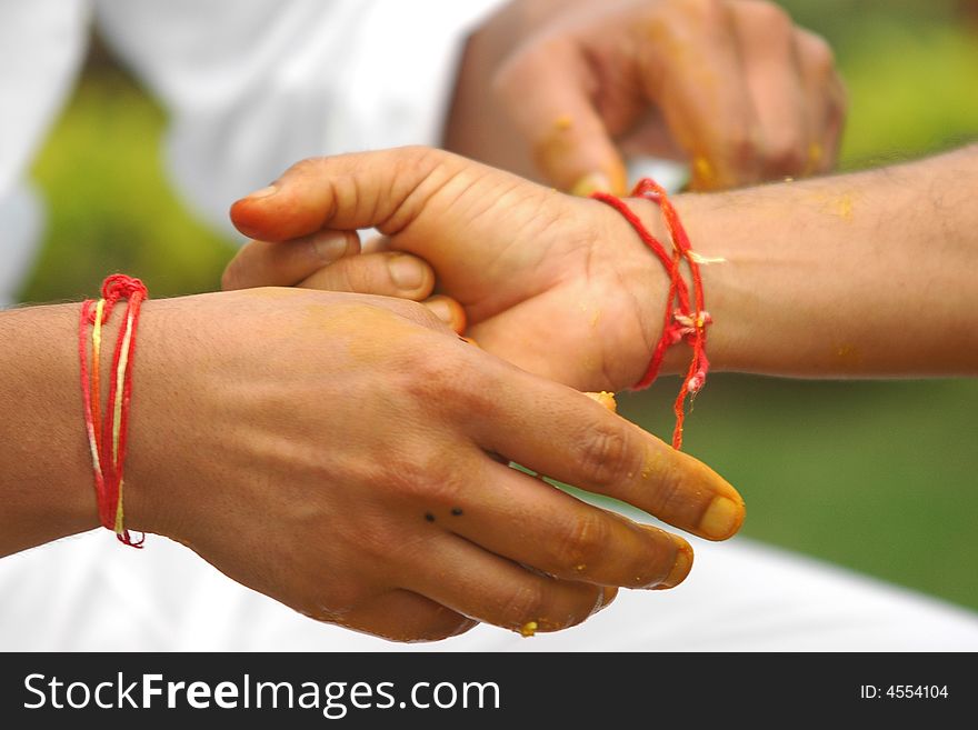 Hindu marriage ceremony. Tying sacred thread on groom's wrist.