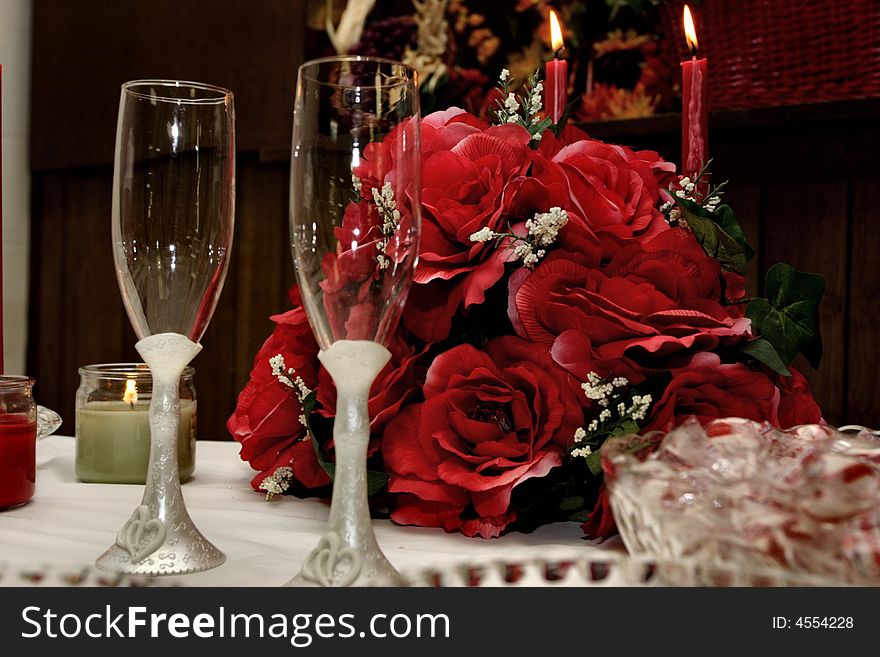 A set of glasses in front of a bouquet of red flowers. A set of glasses in front of a bouquet of red flowers