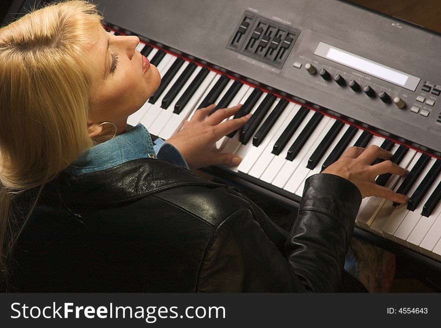 Female Musician Sings While Playing Digital Piano. Female Musician Sings While Playing Digital Piano