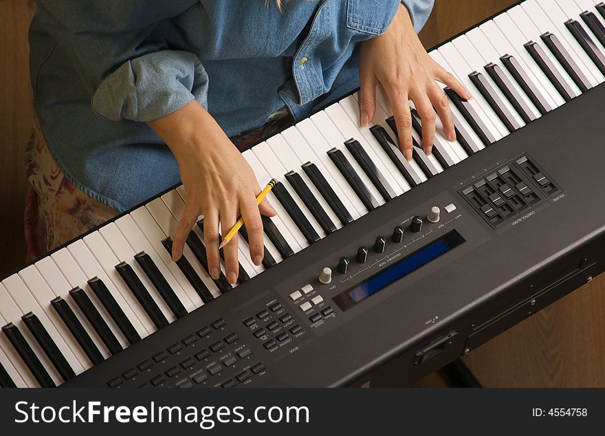 Woman's Fingers with Pencil on Digital Piano Keys. Woman's Fingers with Pencil on Digital Piano Keys