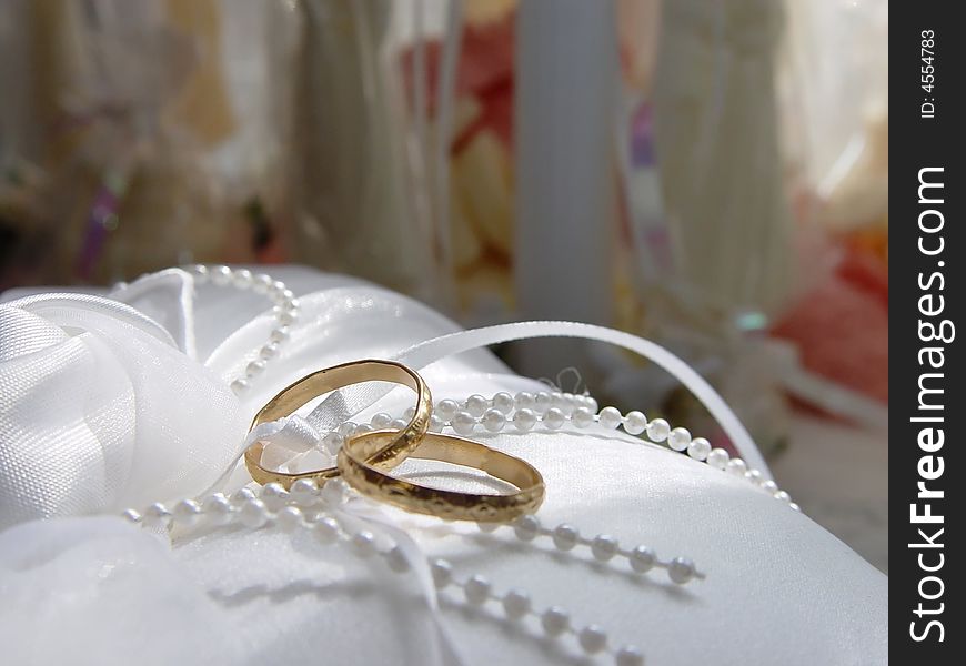 Two intertwined wedding rings resting on a pillow before a wedding. Two intertwined wedding rings resting on a pillow before a wedding