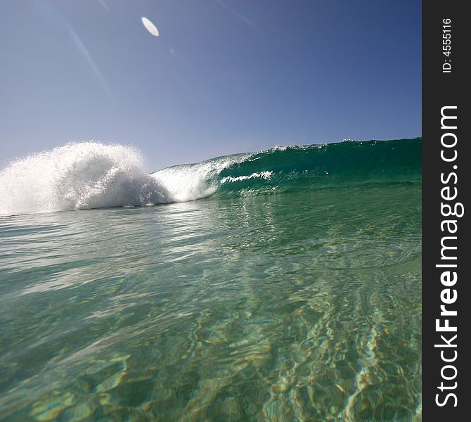 A wave breaking along the sea shore. A wave breaking along the sea shore.