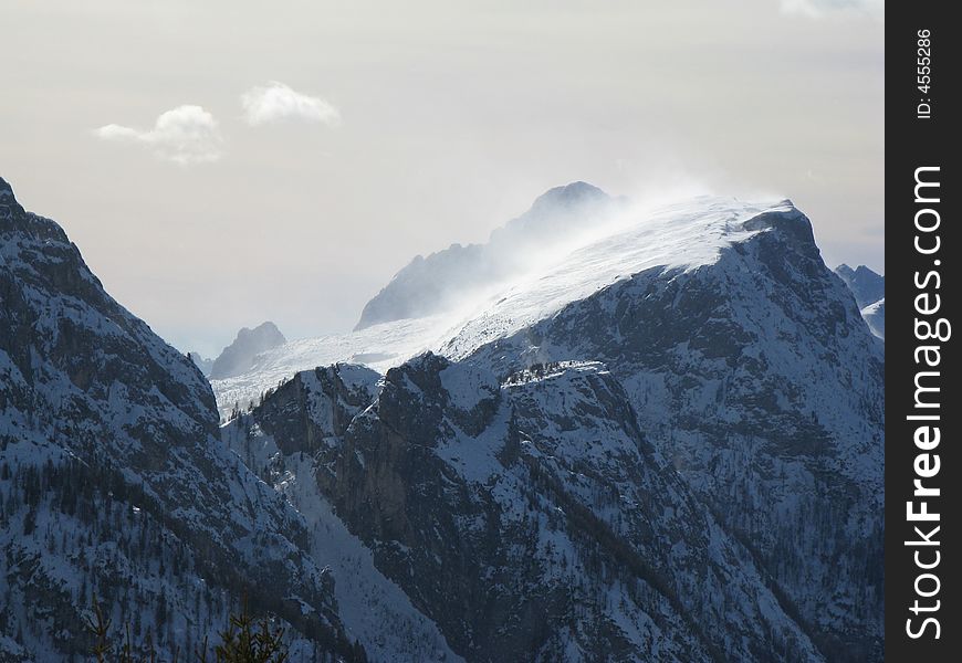 A windstorm is striking mount Civetta on a winter day. A windstorm is striking mount Civetta on a winter day