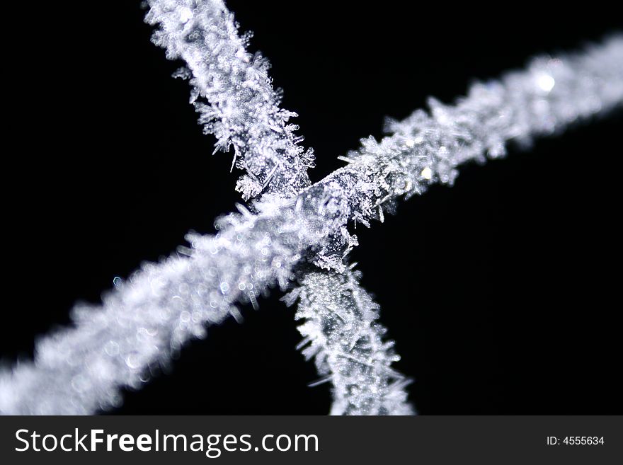 A very up-close image of frost crystals on a black background. A very up-close image of frost crystals on a black background.