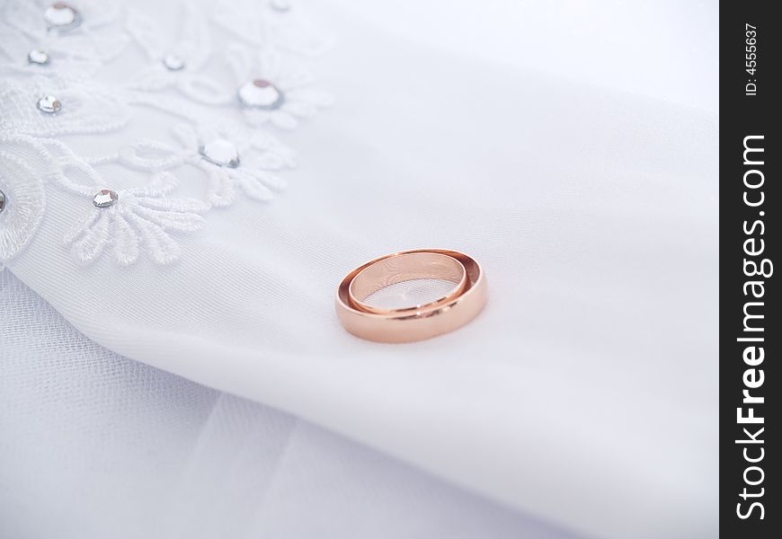 Closeup of wedding rings on a white glove