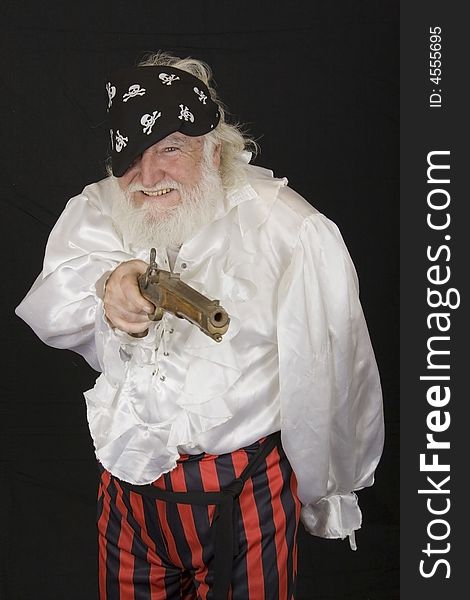 An old man dressed as a pirate with a gun. An old man dressed as a pirate with a gun