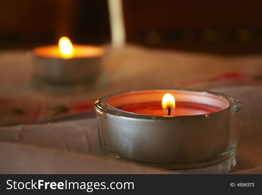 Two votive candles are burning on decorated table. Two votive candles are burning on decorated table.