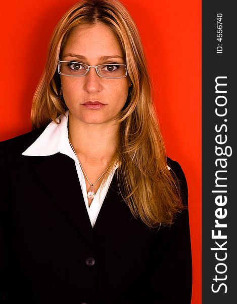 Woman with glasses in business suit on red background. Woman with glasses in business suit on red background.