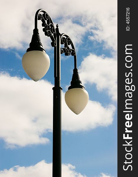 Black lamp post and partly cloudy sky. Black lamp post and partly cloudy sky