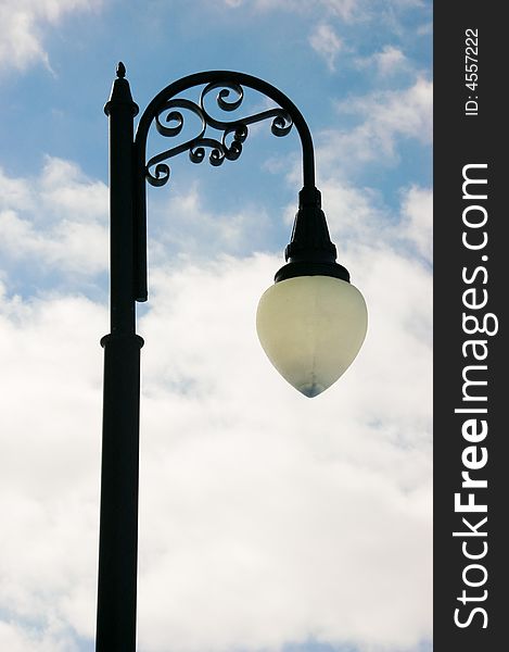 Black lamp post and partly cloudy sky. Black lamp post and partly cloudy sky