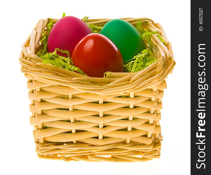 Three multi-coloured Easter eggs in a basket on a white background. Three multi-coloured Easter eggs in a basket on a white background