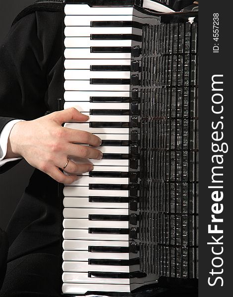 The keyboard of an accordion with a hand of the musician