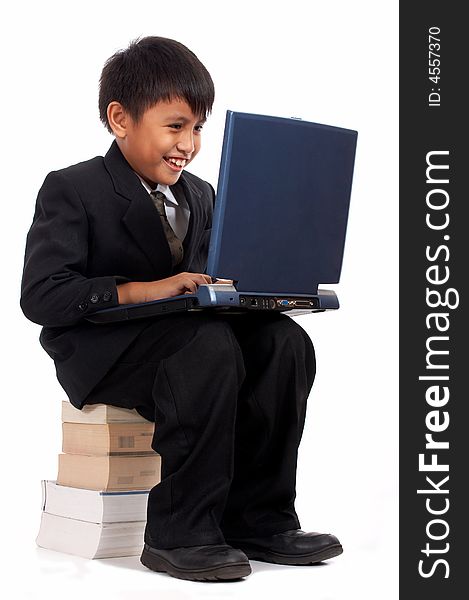 Young businessman with laptop sitting on a stack of books