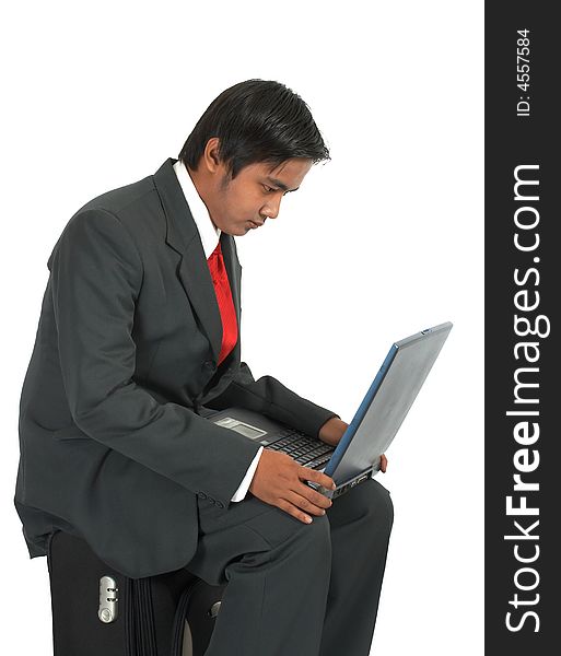 A man sitting on his luggage over a white background. A man sitting on his luggage over a white background