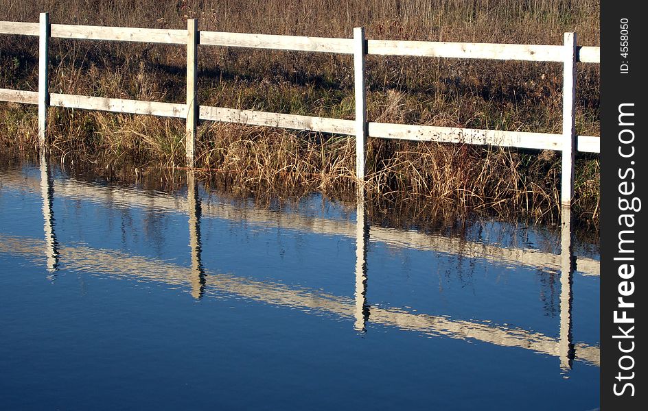 Wooden fence and water in the countryside