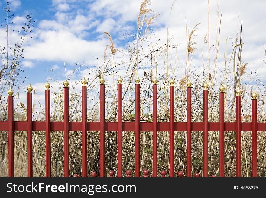 A red iron fence as a demarcation of a lake