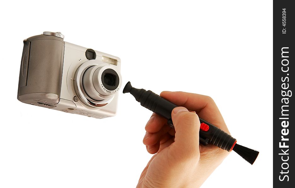 A hand cleaning a lens of camera with a tool,isolated on white. A hand cleaning a lens of camera with a tool,isolated on white