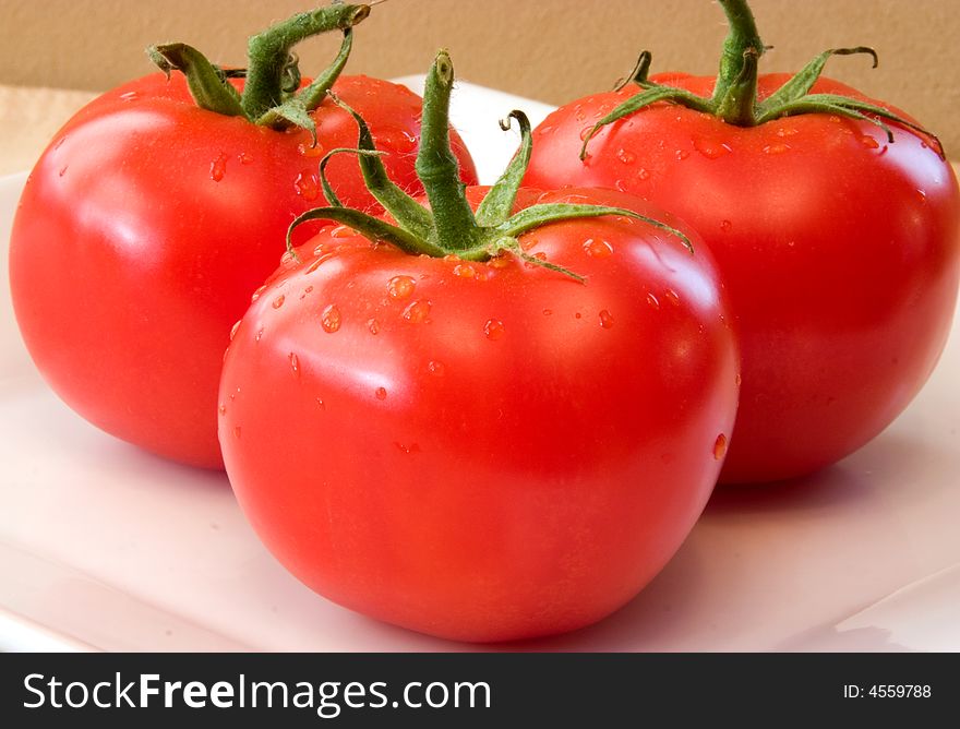 Fresh Vine Ripened Tomatoes on a white plate. Red Tomatoes hand picked for the grocery market These will add fresh ingredients to your vegetable list. Fresh Vine Ripened Tomatoes on a white plate. Red Tomatoes hand picked for the grocery market These will add fresh ingredients to your vegetable list