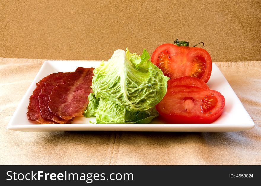 Bacon Lettuce Tomato on a white plate
3 Strips of bacon with crisp lettuce and sliced tomato.