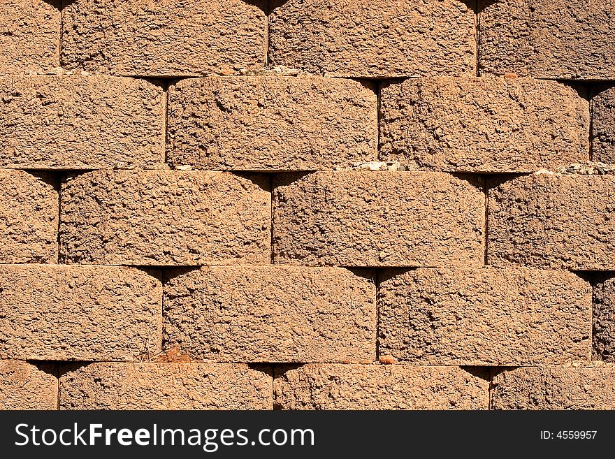 An interlocking retaining wall of red cement blocks. An interlocking retaining wall of red cement blocks