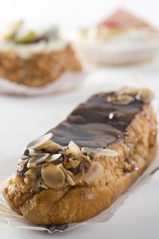 Chocolate Eclair. Cupcakes In Background. Royalty Free Stock Photography Chocolate Eclair. Cupcakes In Background. Royalty Free Stock Photography