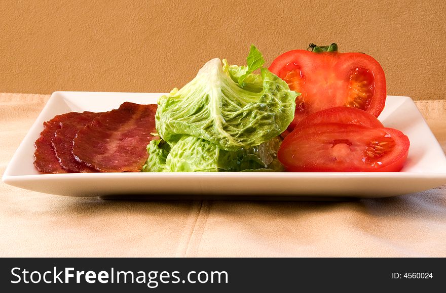 Bacon Lettuce Tomato on a white plate
3 Strips of bacon with crisp lettuce and sliced tomato.